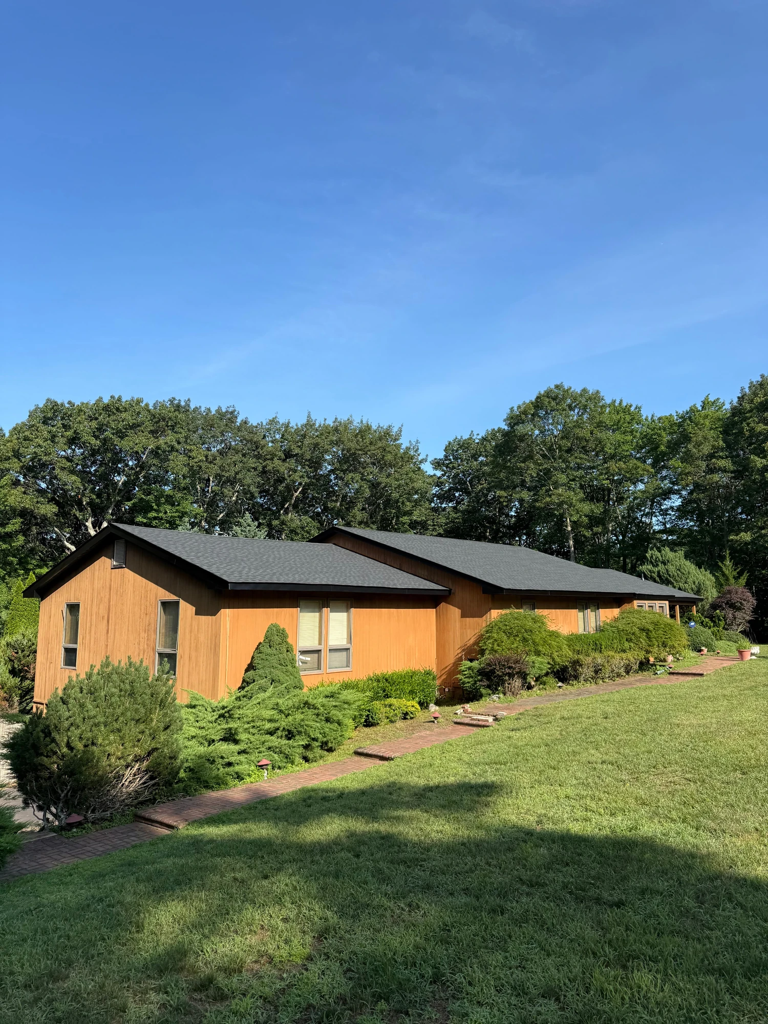 Roof on a brick ranch beside a lawn