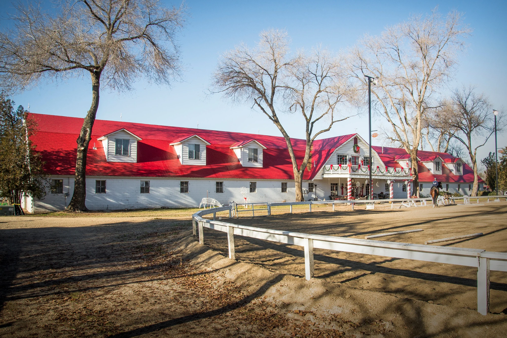 Roof on a red barn beside a paddock